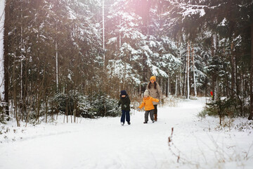 Wall Mural - Happy family playing and laughing in winter outdoors in the snow. City park winter day.