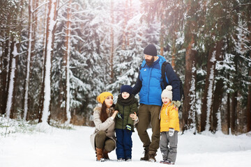 Wall Mural - Happy family playing and laughing in winter outdoors in the snow. City park winter day.