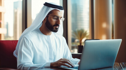 Aufkleber - Portraits of a successful businessman in traditional emirates white dress, Arab man working in his business office of Dubai using laptop.