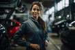 Portrait of young female automobile mechanic working in a clean modern garage shop, standing pose with arms in her waist