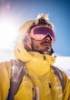 © Glittering Humanity - A stunning portrait of a winter adventurer, clad in a bright yellow jacket and vibrant pink goggles, standing against the snowy backdrop of the sky, donning a ski mask and sunglasses