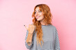 © luismolinero - Young caucasian woman isolated on pink background pointing to the side to present a product