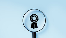 Magnifying Glass Focuses On Quality Warranty Icon, Quality Assurance, ISO Certification, And Standardization Concept. Compliance To Regulations. Blue Background