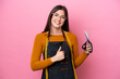 © luismolinero - Young Brazilian seamstress woman isolated on pink background giving a thumbs up gesture