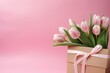 Bouquet of pink tulips and gift box on pink background

