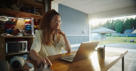 Poster - Young Hispanic Female Software Engineer Programming On Laptop Computer In Opened Garage. Woman Running A Startup With Innovative Online Solution For Businesses. Businesswoman Coding, Optimizing System