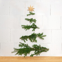 Homemade Christmas Decoration Made Of Natural Branches Nailed Horizontally To The Wall And A Paper Star As A Top, Simple And Sustainable Fir Tree Alternative, Copy Space
