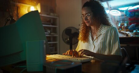 Fototapete - Hispanic Female Engineer Using Old Desktop Computer In Nineties Retro Garage In The Evening. Intelligent Woman Writing Code, Working On Innovative Portable Device, Starting Tech Startup Company.