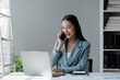 © PhotosD - Businesswoman talking on the phone, business communication, telephone communication, Asian businesswoman working in a financial consulting service company, telephone consultation.
