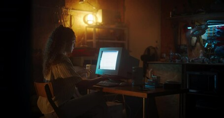 Leinwandbilder - Hispanic Female Web Designer Using Old Desktop Computer In Retro Garage Late At Night. Focused Internet Enthusiast Writing Code At Home. Programming Successful Social Network Website In Nineties.