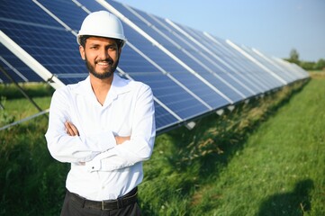 Wall Mural - Portrait young indian technician or manager wearing formal cloths standing with solar panel. renewable energy, man standing crossed arm, copy space