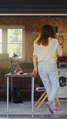Fototapete - Vertical Screen: Hispanic Woman Opening Garage Door And Sitting Behind Laptop Computer In Garage. Female E-commerce Startup Founder Creating Online Service. Businesswoman Starting Digital Marketplace.