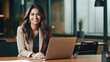 © PixelGallery - Indian business woman sitting in office using laptop with smiling face
