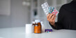 Woman hold bottle of drug tablet painkiller or vitamin supplement reading label ready to organizing medicine at home. medication healthcare concept