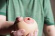 hand squeezing or groping boob shaped anti-stress ball