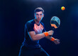 Beach tennis player with racket. Man athlete playing isolated on black background.