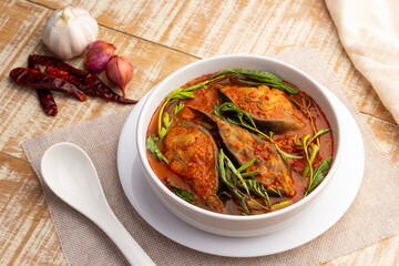 Wall Mural - Thai Sour soup with catfish and water mimosa in white bowl on wooden table