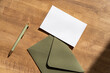 Blank sheet of paper on brown envelope, pen on the desk. Greeting, wedding or congratulations stationery mockup