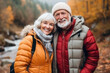 © FoxTok - Couple of happy smiling pensioners outdoors in autumn forest, park. Gray-haired man and middle-aged woman are hugging and enjoying life. Concept of active elderly people, traveling