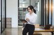 Asian woman using digital tablet and standing at office.