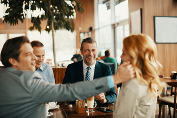 Wall Mural - Diverse group of business friends having coffee after work in a café decorated for Christmas and the new year holidays