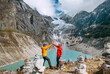 © Soloviova Liudmyla - Trekkers couple dressed bright waterproof jackets giving High Five enjoying glacier falling in high altitude Sabai Tso glacial lake 4350m. Makalu Barun National Park, Mera peak climbing route, Nepal