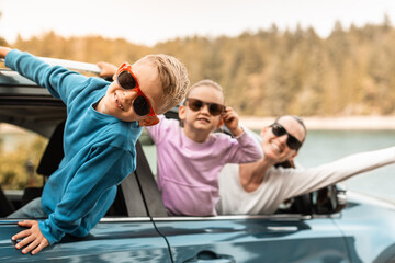 Wall Mural - Portrait of happy mother and child in car smiling enjoying weekend family holiday road trip	