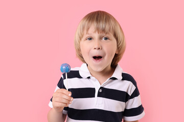 Wall Mural - Emotional little boy with lollipop on pink background