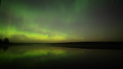 Wall Mural - spectacular green aurora fills the sky and reflect in the water at the start of the clip. they then 