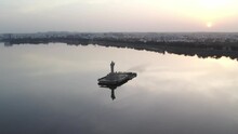 A Aerial Beautiful Sunrise Over The Indian City Of Hyderabad Cinematic Footage Of Hyderabad's Most Famous Area, Hussain Sagar Lake. The Sun And Clouds Reflect Over The Lake. Buddha Statue Of Hyderabad