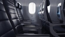Slow Push In Across A Row Of Blue, Empty Leather Seats In A Commercial Passenger Airplane.