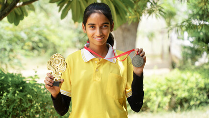 Excited Indian student school child wearing school uniform holding victory trophy in hand, Education concept.