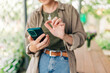 © Olga Krivokoneva - Woman hands close-up holding mobile phone device in the yard house terrace
