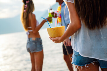 Wall Mural - Group of friends at beach drinking cocktails having fun on summer vacation. People travel concept