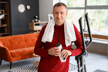 Sticker - Sporty mature man with bottle of water after training at home