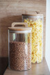 Jars with buckwheat groats and pasta on a wooden table