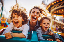 Mother And Two Children Riding A Roller Coaster Together Having Fun. Happy Family On A Fun Roller Coaster Ride In An Amusement Park. Laughing.