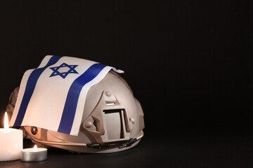 Wall Mural - Military helmet with flag of Israel and burning candles on dark background