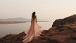 © UsamaR - Backside of a woman in a light pink long dress standing
