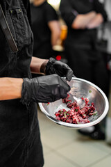 Wall Mural - professional chef's hands cooking Raw beef meat tartar in restaurant kitchen