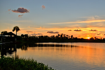 Wall Mural - beautiful evening sunset over the river in a recreation area with houses. AI GENERATE