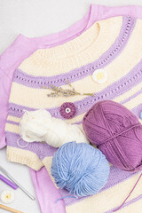 Wall Mural - Handmade crocheted baby t-shirt in lilac tones. Stuff contains thread, hooks, knitting needles