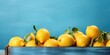 Summer holiday banner with fresh citrus fruits in a wooden box, summer accessories and lemons on a blue background with copy space.