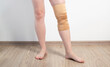 Orthopedic medical kneecap on the leg of a girl. Fixation and support of the knee joint after injury.