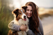 Photo of young happy female hugging dog