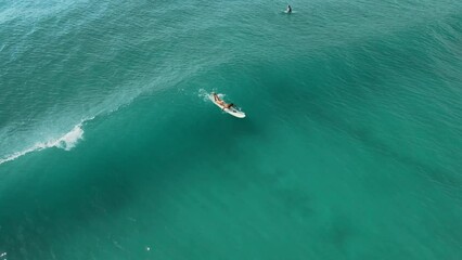 Wall Mural - Aerial view of woman during surfing. Surfer on surf board and ocean wave