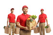 © Ljupco Smokovski - Team of delivery men with bags of groceries smiling at camera