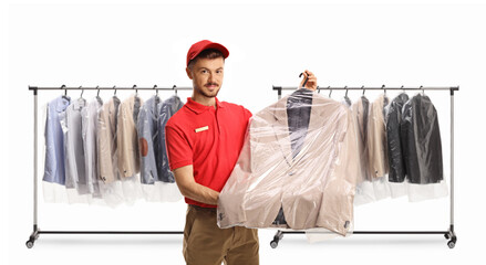 Sticker - Dry cleaning worker holding a suit in a plastic bag cover in front of clothes hanging on a rack