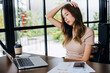 © sorapop - Asian business woman suffering from neck ache pain caused by long time laptop usage, Tired office woman sitting at desk touching massaging stiff neck while holding her head in cafe coffee shop