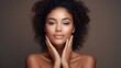 © koplesya - a beautiful curly young mulatto woman with clean fresh skin touches her own face. Facial care. Cosmetology, beauty and spa